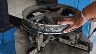 Motosiklet tamirhanesinde, motosiklet lastiklerini değiştirmek.