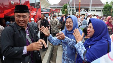 Endonezyalı Müslüman hacılar için sevinçli bir an. Aile ve arkadaşlar, tur otobüsünün yanında birbirlerini duygularıyla selamlarlar. İslam geleneği ve birliğinin kutlanması, Pekalongan, Endonezya, 19 Haziran 202