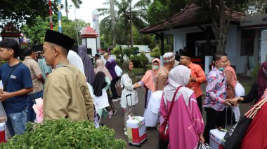 Endonezyalı Müslüman hacılar için sevinçli bir an. Aile ve arkadaşlar, tur otobüsünün yanında birbirlerini duygularıyla selamlarlar. İslam geleneği ve birliğinin kutlanması, Pekalongan, Endonezya, 19 Haziran 2025