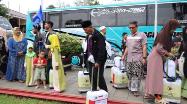 Endonezyalı Müslüman hacılar için sevinçli bir an. Aile ve arkadaşlar, tur otobüsünün yanında birbirlerini duygularıyla selamlarlar. İslam geleneği ve birliğinin kutlanması, Pekalongan, Endonezya, 19 Haziran 2025