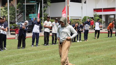 Endonezya Bağımsızlık Günü kutlamaları sırasında bir çuval yarışı yarışına katılan kadınlar ve erkekler. 14 Ağustos 2025 'te Pekalongan, Orta Cava' da neşeli takım çalışması ve yerel gelenek.