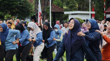 Şenlikli kalabalık ve ulusal gururla heyecanlı bir takım oyunu. Erkekler, Endonezya Bağımsızlık Günü kutlamaları sırasında 14 Ağustos 2025 'te Pekalongan, Orta Java' da geleneksel bir bakiak yarışında yarışıyorlar..