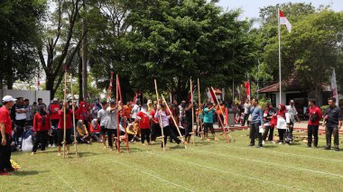 Şenlikli kalabalık ve ulusal gururla heyecanlı bir takım oyunu. Erkekler, Endonezya Bağımsızlık Günü kutlamaları sırasında 14 Ağustos 2025 'te Pekalongan, Orta Java' da geleneksel bir bakiak yarışında yarışıyorlar..
