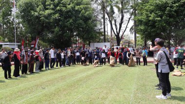 Şenlikli kalabalık ve ulusal gururla heyecanlı bir takım oyunu. Erkekler, Endonezya Bağımsızlık Günü kutlamaları sırasında 14 Ağustos 2025 'te Pekalongan, Orta Java' da geleneksel bir bakiak yarışında yarışıyorlar..