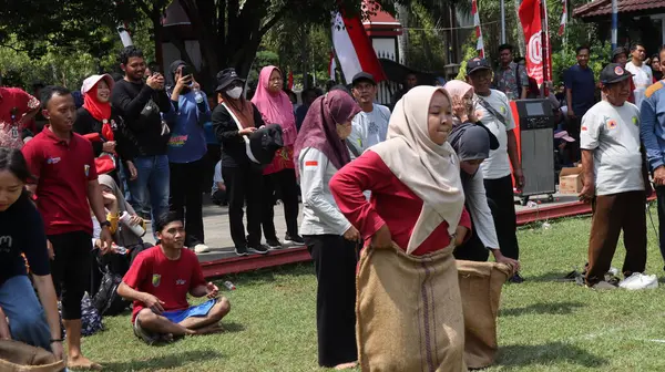 Endonezya Bağımsızlık Günü kutlamalarında kadın ve erkeklerin çuval yarışı yarışına katıldığı bir editör fotoğrafı. 14 Ağustos 2025 'te Pekalongan, Orta Cava' da neşeli takım çalışması ve yerel gelenek