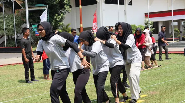 Şenlikli kalabalık ve ulusal gururla heyecanlı bir takım oyunu. Erkekler, Endonezya Bağımsızlık Günü kutlamaları sırasında 14 Ağustos 2025 'te Pekalongan, Orta Java' da geleneksel bir bakiak yarışında yarışıyorlar..