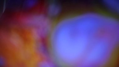 Canlı mavi, mor ve turuncu renklerin soyut karışımı yumuşak, rüya gibi bir doku yaratıyor ve derinlik ve hareket hissi veriyor..