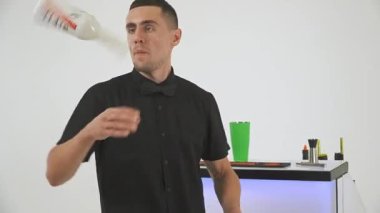 Barmen beyaz arka planda bir şişe ve karıştırıcı ile bir numara yapıyor. Yüksek kaliteli FullHD görüntüler