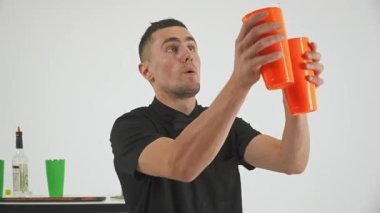 Barmen beyaz arka planda bir şişe ve karıştırıcı ile bir numara yapıyor. Yüksek kaliteli FullHD görüntüler