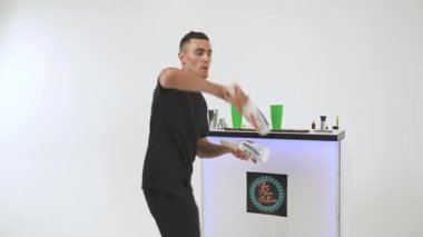 Barmen beyaz arka planda bir şişe ve karıştırıcı ile bir numara yapıyor. Yüksek kaliteli FullHD görüntüler