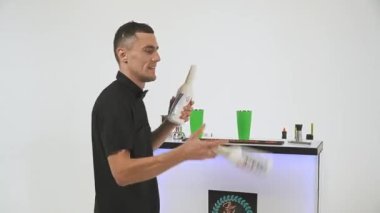 Barmen beyaz arka planda bir şişe ve karıştırıcı ile bir numara yapıyor. Yüksek kaliteli FullHD görüntüler