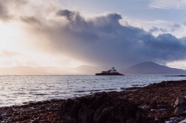 Aerial panorama view of the historic Fenit Lighthouse in Tralee Bay, beautiful clouds, sunset. High quality photo