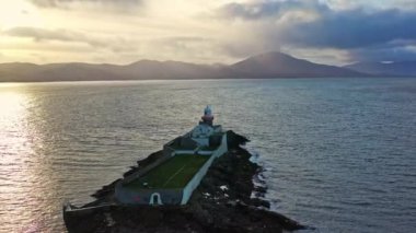 Aerial panorama view of the historic Fenit Lighthouse in Tralee Bay, beautiful clouds, sunset. High quality 4k footage