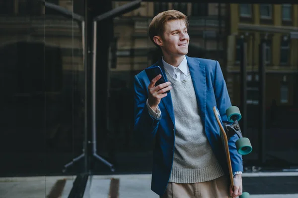笑顔ハンサムな若い男ビジネスマンは 携帯電話を保持ロングボードを使用してスーツメッセージングを着て — ストック写真