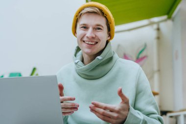 Genç blogcu dışarıda kameraya bakarak video blogu yazıyor. Seçici odak.