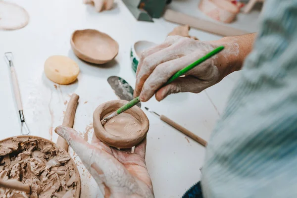 stock image Close up of female hands working with clay making a cup in a workshop. Selective focus.