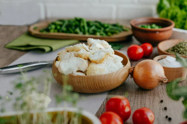 Mutfakta işlenmiş ahşap tabakta dilimlenmiş erinezyum mantarlar. Evde yetişen Lions yelesi mantarı. Mantar kültürü ve ev bahçesi kavramı. Seçici odak.
