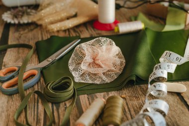 İş yerindeki ahşap masada el yapımı dekor çiçeği. Giysi geliştirme konsepti.