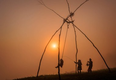 Kabile salıncakları güneş ışığıyla bir dağda oturuyor. 