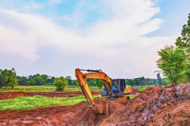 Kepçe, kepçenin manzarası yere bir çukur kazıyordu. Büyük çaplı kazı araçları bir gölet kazıyor. İnşaat alanında kepçe kazıcı. 
