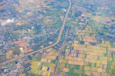 Dağların, nehirlerin, bulutların, tarımsal arazilerin, yeşil ve sarı pirinç tarlalarının havadan görünüşü farklı şekillerde büyüdü ve konakladı..