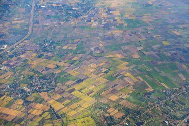 Dağların, nehirlerin, bulutların, tarımsal arazilerin, yeşil ve sarı pirinç tarlalarının havadan görünüşü farklı şekillerde büyüdü ve konakladı..
