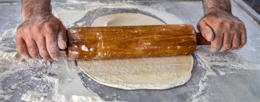 Pizza hamuru yapan bir erkeğin elleri. 