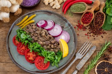 Kızarmış Arnavut ciğeri, soğan ve roka. Ciger kavurma veya ciger tava 