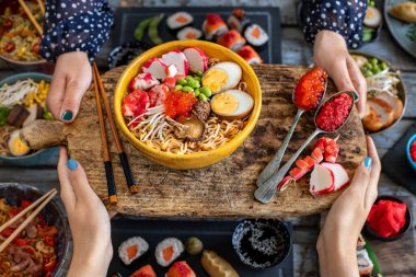 İki kadının elinde deniz mahsulü ramen. Havyarlı makarna, bok ve karides.. 