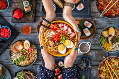 İki kadının elinde deniz mahsulü ramen. Havyarlı makarna, bok ve karides.. 