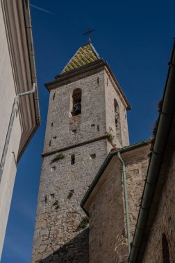 Ön cephe basittir, taş küller içinde, Aziz Peter 'ın anahtarlarıyla süslenmiş bir taç ile. Çan kulesi yeşil ve sarı karolarla süslenmiş bir kuledir..