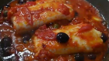 Domates sosu ve zeytin ve kapari ile pişirilmiş morina balığı, güçlü ve dengeli bir Akdeniz tadında lezzetli bir ikinci yemektir..