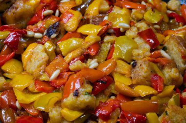 Biberler bir tavada pişiriliyor ve bayat ekmekten yapılan bir sos ile tatlandırılıyor ve tercih ettiğiniz diğer malzemeler, pekorino, maydanoz ve diğerleri gibi..