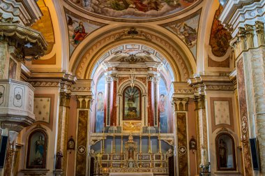 Kilisenin altı yan şapeli olan bir komisyon üyesi çapraz planı var. Merkez körfezin etrafını lunetlerle dolu bir fıçı kasası sarmış, yükseltilmiş papaz evi yarım küresel bir kubbeyle kaplanmış..