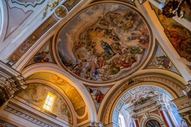 Kilisenin altı yan şapeli olan bir komisyon üyesi çapraz planı var. Merkez körfezin etrafını lunetlerle dolu bir fıçı kasası sarmış, yükseltilmiş papaz evi yarım küresel bir kubbeyle kaplanmış..