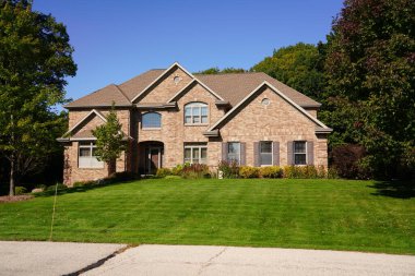 Çimleri ve yeşil çimenleri olan modern lüks bir ev..