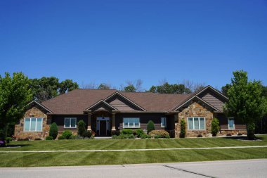 Fond du Lac, Wisconsin USA - 25 Haziran 2022: Lüks taştan tuğla ev varlıklı bir evde bulunuyor.
