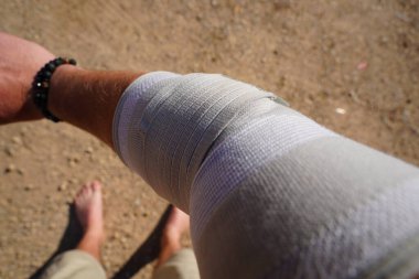 Kolundaki bandajı tutan kişinin yakından çekilmiş bir fotoğrafı.