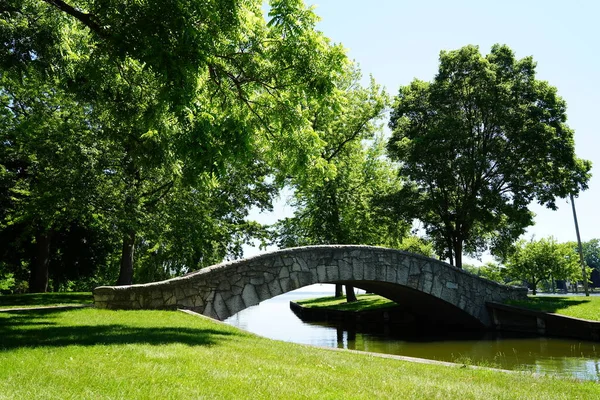 カーブストーンブリッジは公園を走る川の上にアーチ — ストック写真
