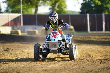 ATV dört tekerli bisikletler bir toprak pistte bir süper haç motorsporu yarışında yarışmış ve dublörlük yapmıştır..