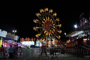 Cemaatten aileler, yerel bir lunaparkta eğlenmek için gece dışarı çıktılar..