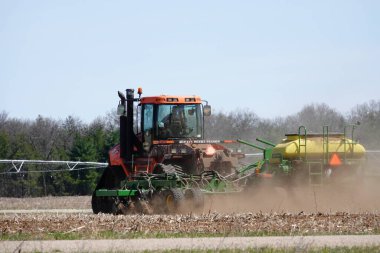 Yeni Lizbon, Wisconsin ABD - 5 Mayıs 2023: Orange Case IH Steiger 380 DS Quadtrac traktörü ekin tarlasında tarım.