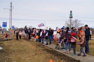 Oakdale, Wisconsin ABD - 4 Mart 2022: Pro Amerikalılar ve Trump taraftarları, I90 ve I94 otobanlarında Özgürlük Konvoyuna destek veren bayraklar sallayarak toplandılar.