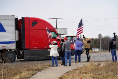 Oakdale, Wisconsin ABD - 4 Mart 2022: Pro Amerikalılar ve Trump taraftarları, I90 ve I94 otobanlarında Özgürlük Konvoyuna destek veren bayraklar sallayarak toplandılar.