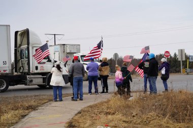 Oakdale, Wisconsin ABD - 4 Mart 2022: Pro Amerikalılar ve Trump taraftarları, I90 ve I94 otobanlarında Özgürlük Konvoyuna destek veren bayraklar sallayarak toplandılar.