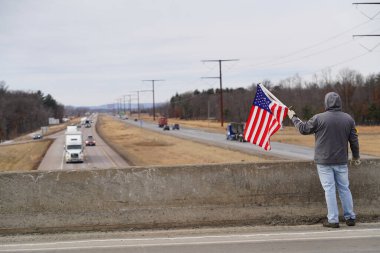 Oakdale, Wisconsin ABD - 4 Mart 2022: Pro Amerikalılar ve Trump taraftarları, I90 ve I94 otobanlarında Özgürlük Konvoyuna destek veren bayraklar sallayarak toplandılar.