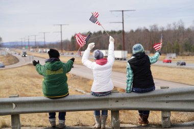 Oakdale, Wisconsin ABD - 4 Mart 2022: Pro Amerikalılar ve Trump taraftarları, I90 ve I94 otobanlarında Özgürlük Konvoyuna destek veren bayraklar sallayarak toplandılar.