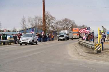 Oakdale, Wisconsin ABD - 4 Mart 2022: Pro Amerikalılar ve Trump taraftarları, I90 ve I94 otobanlarında Özgürlük Konvoyuna destek veren bayraklar sallayarak toplandılar.