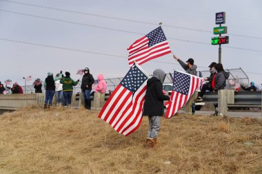 Oakdale, Wisconsin ABD - 4 Mart 2022: Pro Amerikalılar ve Trump taraftarları, I90 ve I94 otobanlarında Özgürlük Konvoyuna destek veren bayraklar sallayarak toplandılar.