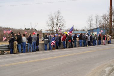 Oakdale, Wisconsin ABD - 4 Mart 2022: Pro Amerikalılar ve Trump taraftarları, I90 ve I94 otobanlarında Özgürlük Konvoyuna destek veren bayraklar sallayarak toplandılar.